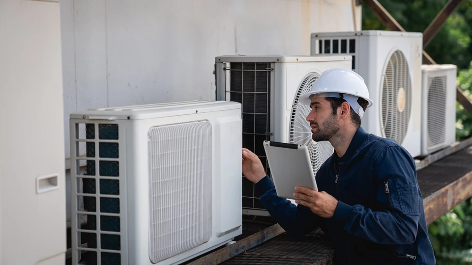 Technicien en climatisation travaillant sur une installation extérieure d'unités de climatisation