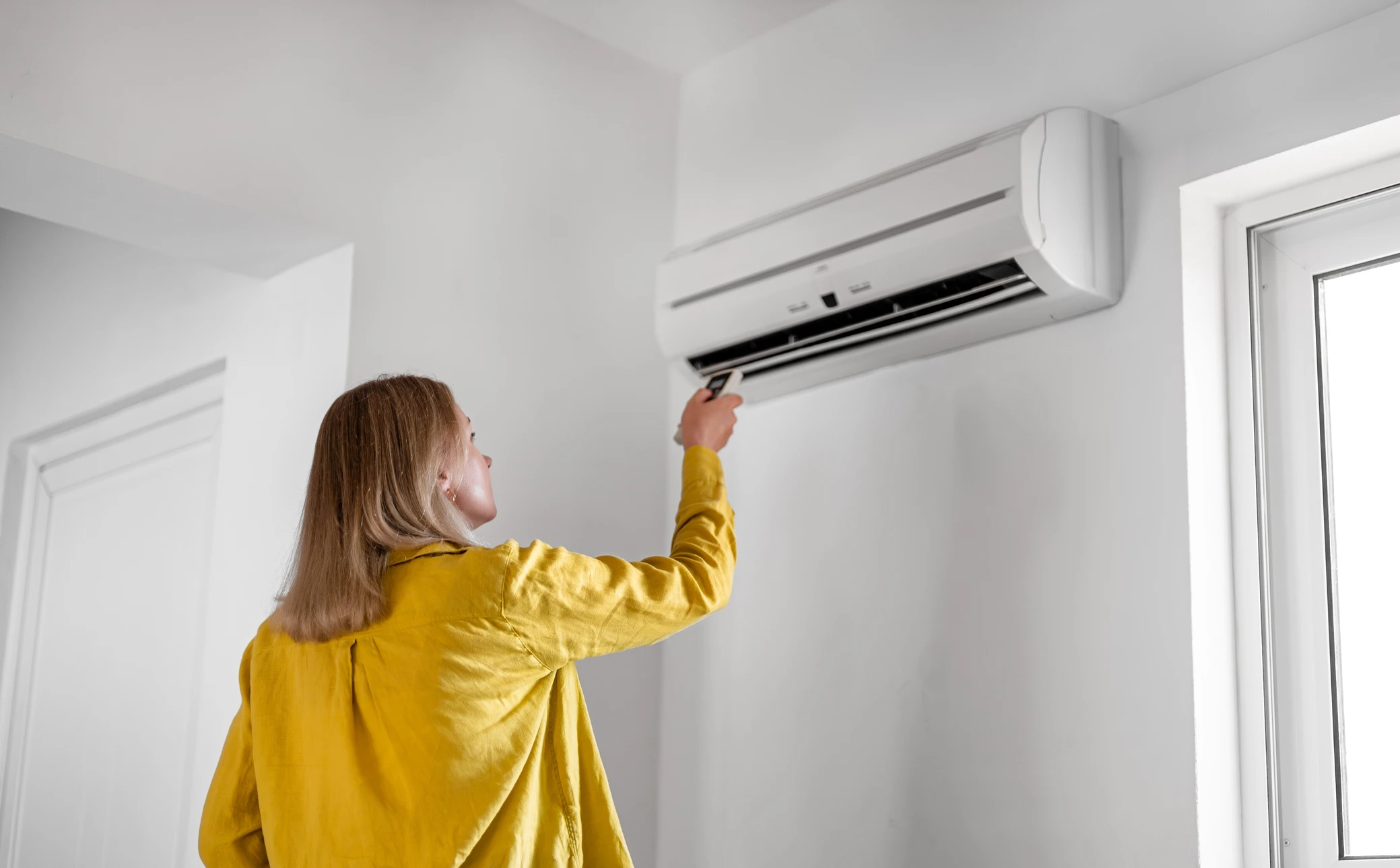 Un technicien travaillant sur la climatisation ou la pompe &agrave; chaleur d'une unit&eacute; ext&eacute;rieure